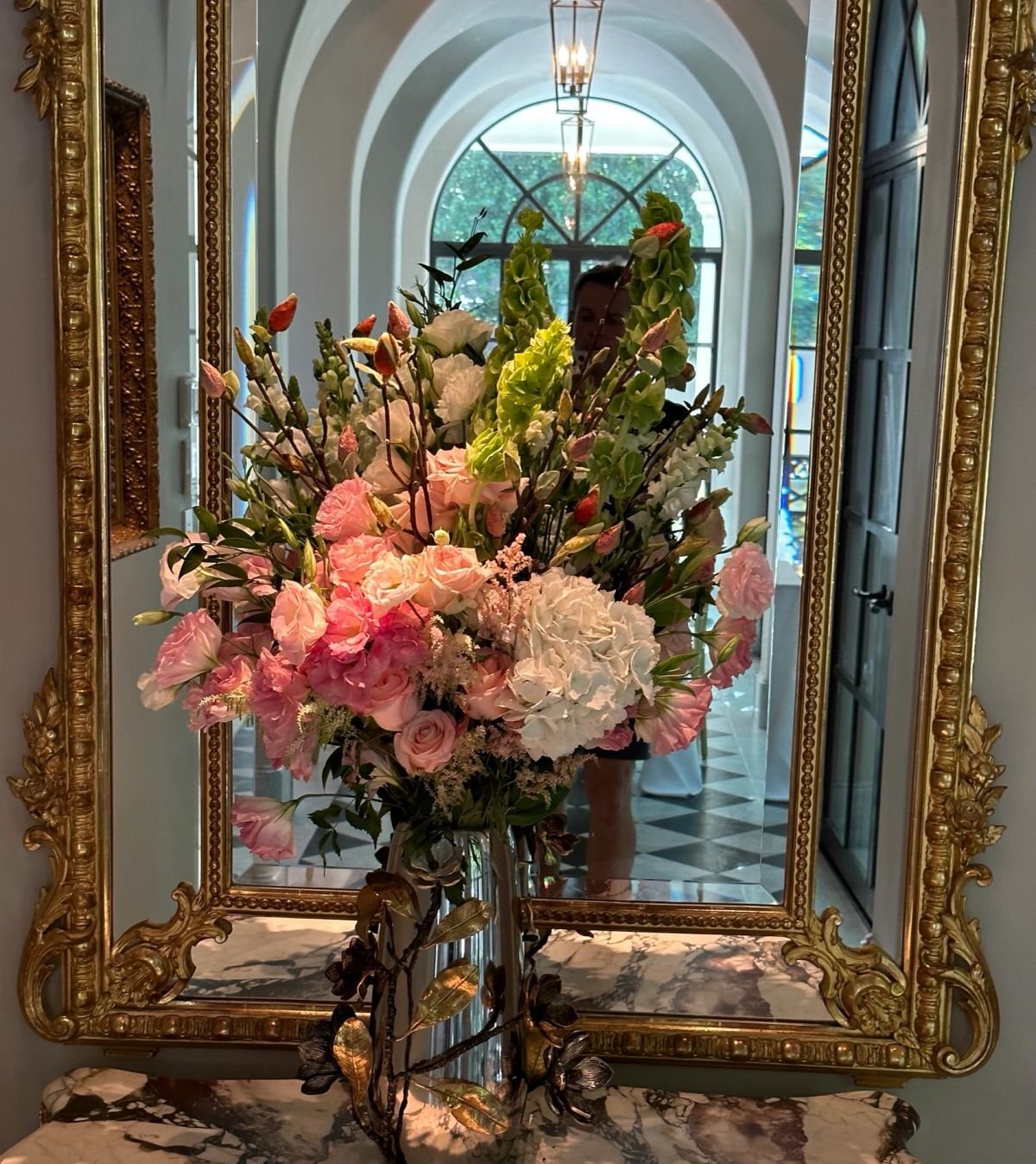 Custom event floral installation framing an ornate mirror