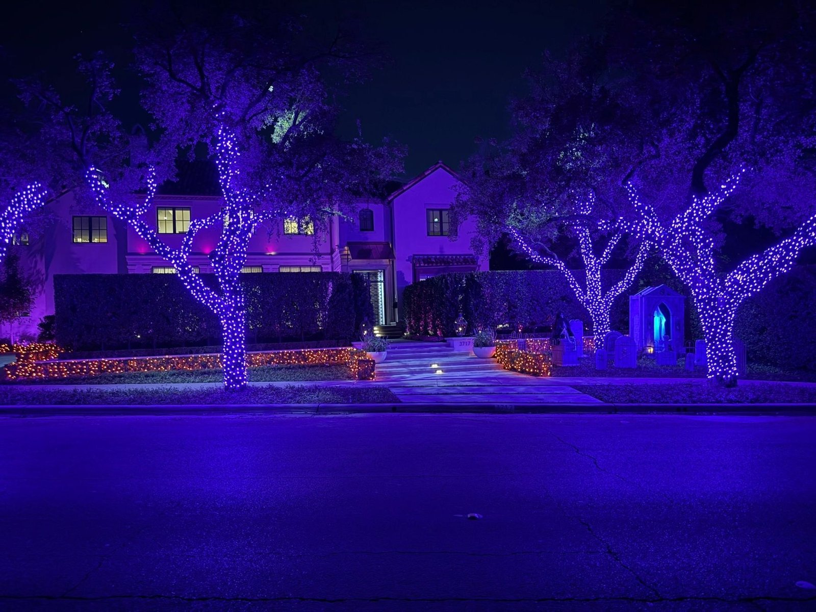 Large residential estate illuminated with purple Halloween lighting